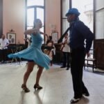 A couple dancing closely indoors while a live band plays, like a 1940s swing dance hall