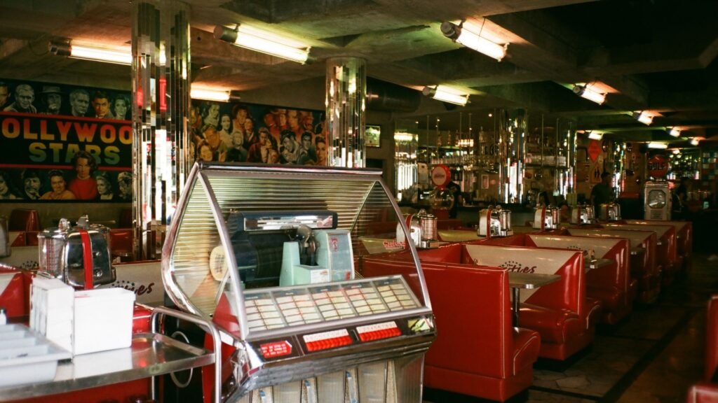 Retro 1950s diner interior with a jukebox, red booths, and chrome details