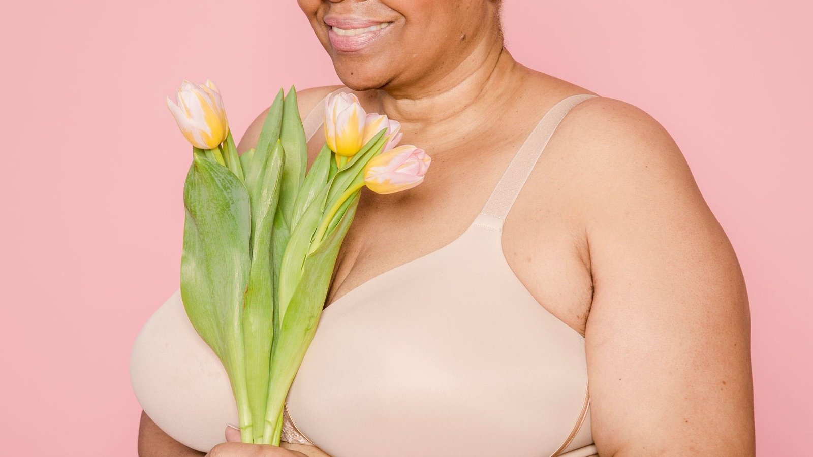 Smiling woman holding tulips in a body-positivity photo shoot