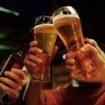 friends toasting beer glasses in a lively pub setting