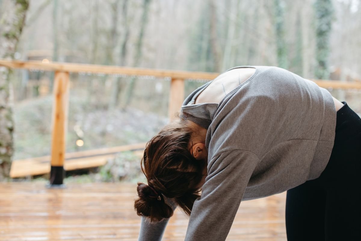 Woman performing the yoga cat pose on an exercise mat, curving her back upward
